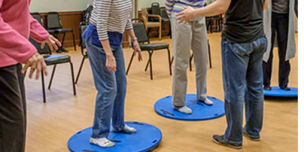 UNCG researchers observe Well•Spring residents on wobble boards.